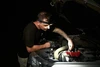 Meccanico con lampada frontale Olight ripara il motore dell'auto di notte.